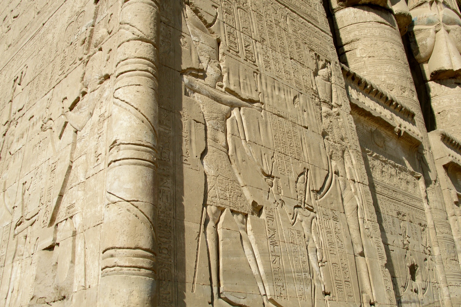 Carved reliefs and hieroglyphic inscriptions covering walls and columns inside the Temple of Hathor at Dendera